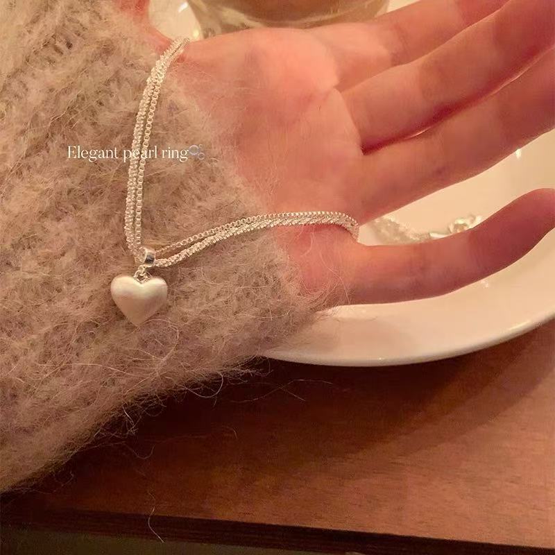 Women's brushed double-layer heart pendant necklace combines elegance and modernity. Crafted from thick, silver-plated white copper.