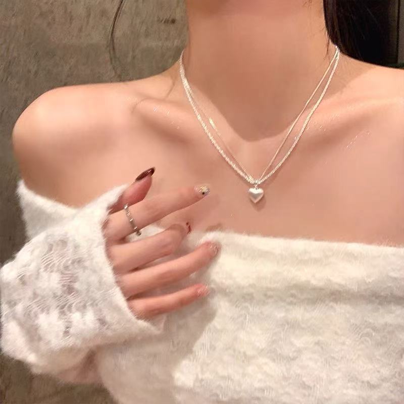 Women's brushed double-layer heart pendant necklace combines elegance and modernity. Crafted from thick, silver-plated white copper.