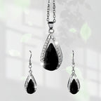 This set of a necklace and a pair of earrings features an elegant design with glass drop pendants.