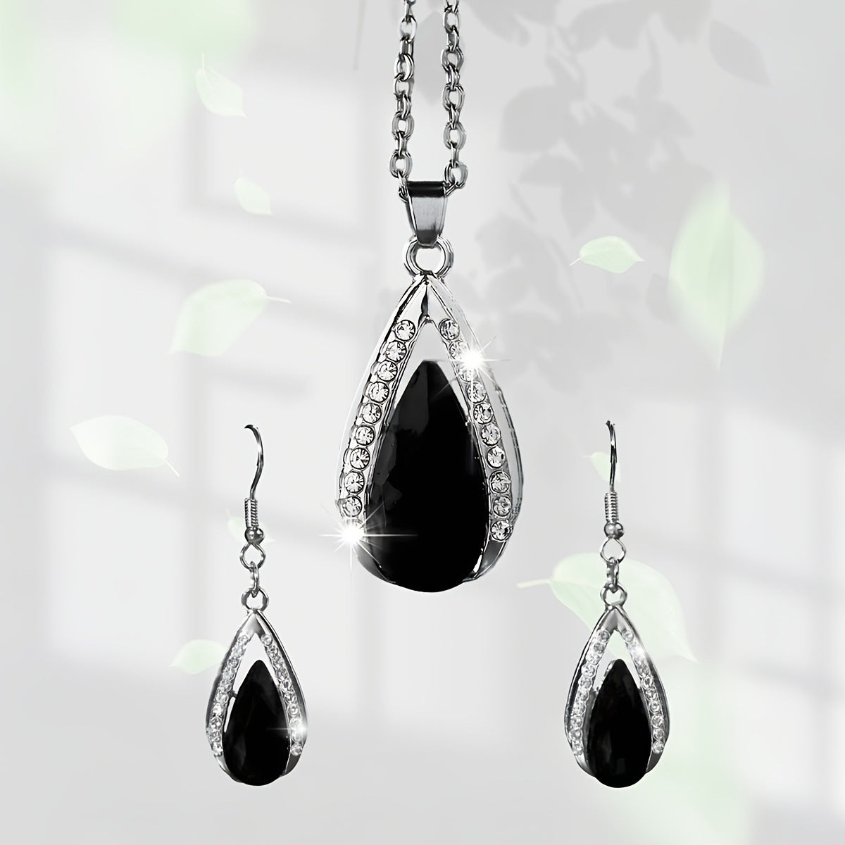 This set of a necklace and a pair of earrings features an elegant design with glass drop pendants.