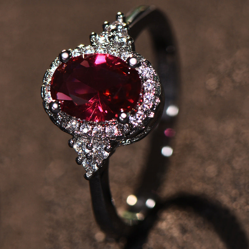 This women's ring is distinguished by its elegant oval shape, highlighting a sublime ruby ​​set in a white gold-plated copper metal.