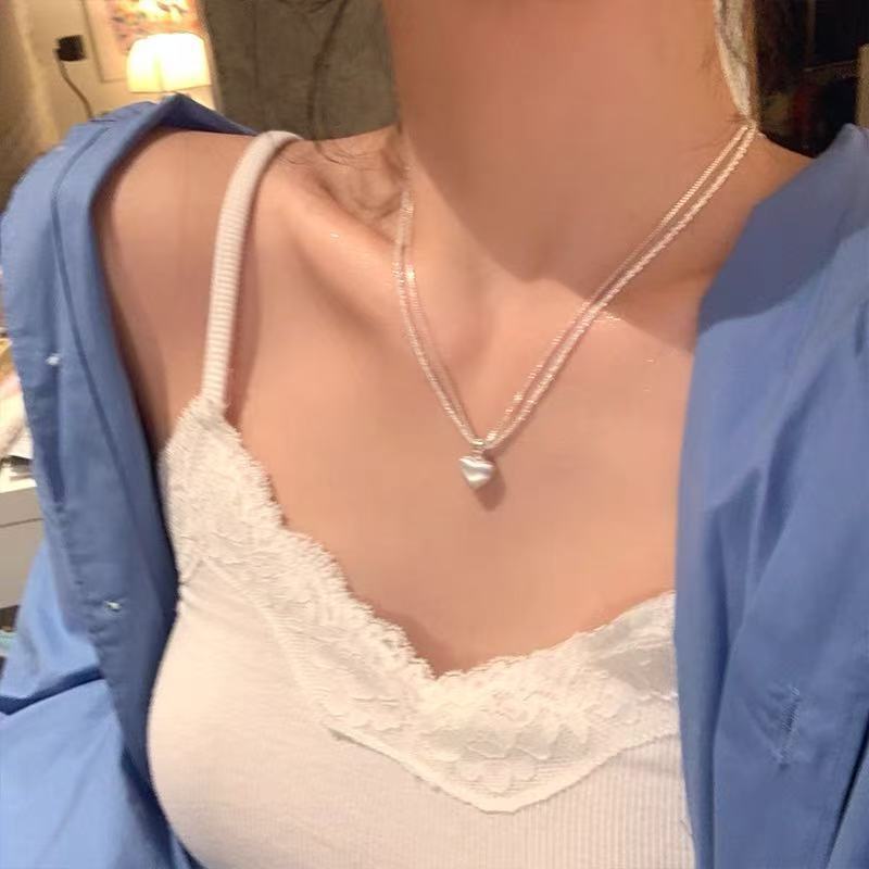 Women's brushed double-layer heart pendant necklace combines elegance and modernity. Crafted from thick, silver-plated white copper.