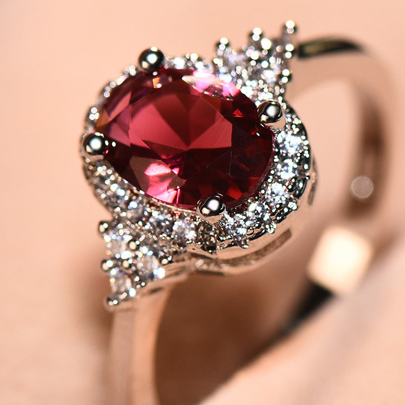 This women's ring is distinguished by its elegant oval shape, highlighting a sublime ruby ​​set in a white gold-plated copper metal.