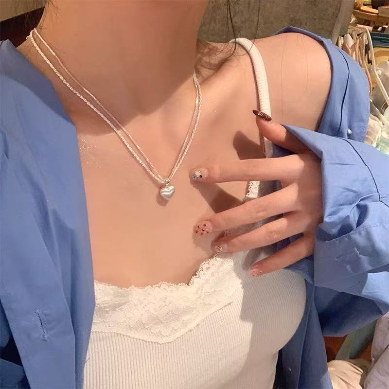 Women's brushed double-layer heart pendant necklace combines elegance and modernity. Crafted from thick, silver-plated white copper.