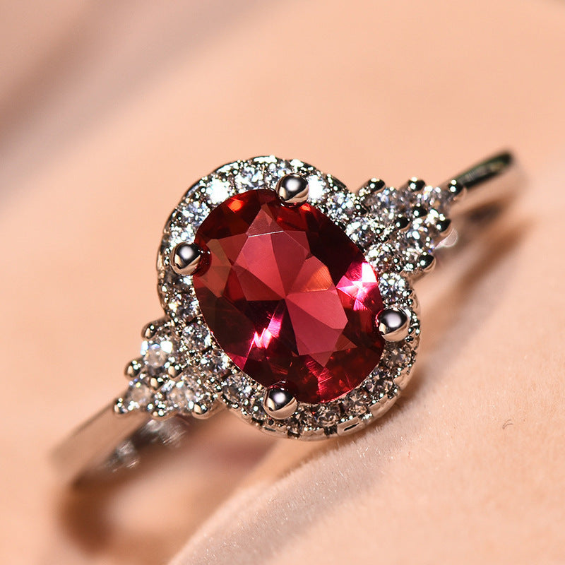 This women's ring is distinguished by its elegant oval shape, highlighting a sublime ruby ​​set in a white gold-plated copper metal.