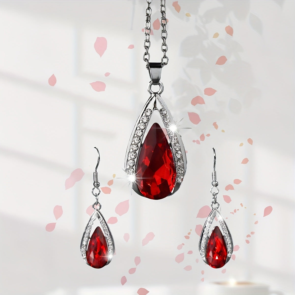 This set of a necklace and a pair of earrings features an elegant design with glass drop pendants.