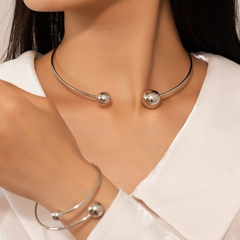 Open bangle bracelet, decorated with balls of various sizes, combines contemporary design and minimalist elegance.