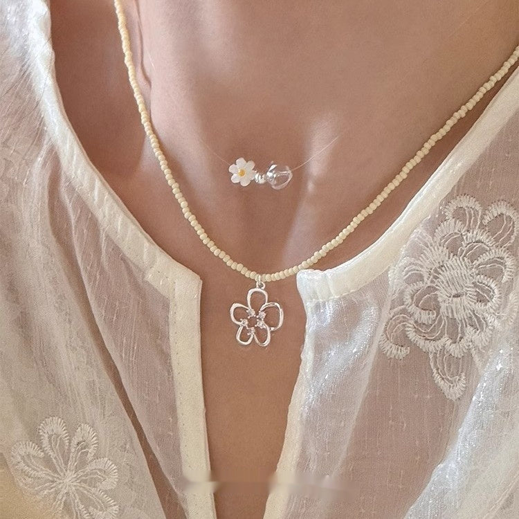 This women's necklace features a vibrant and delicate design, combining colorful yellow or blue beads with a hollow flower pendant.