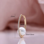 Trendy earrings in champagne gold-plated copper, delicately set with zirconia and adorned with elegant pearls