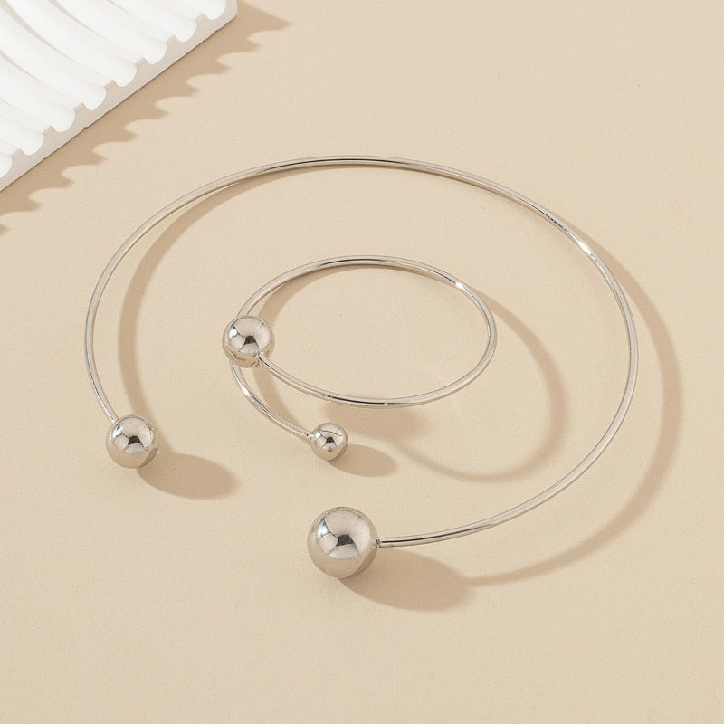 Open bangle bracelet, decorated with balls of various sizes, combines contemporary design and minimalist elegance.