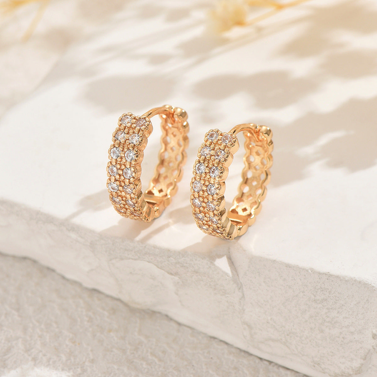 Women's earrings feature a modern geometric design, characterized by round shapes, dots and rings that harmoniously intertwine