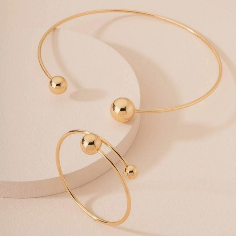 Open bangle bracelet, decorated with balls of various sizes, combines contemporary design and minimalist elegance.