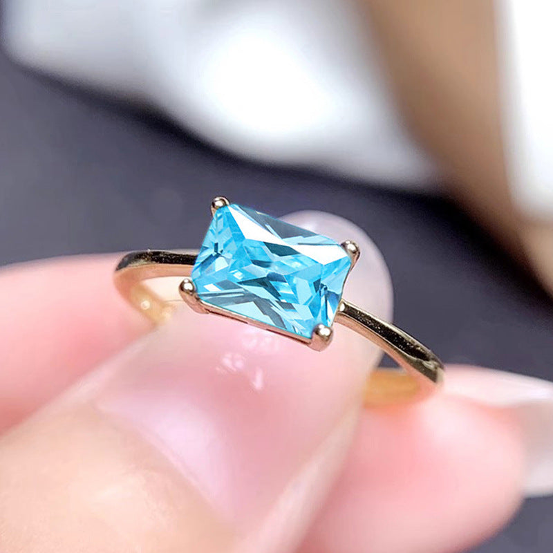 women's ring combines elegance and simplicity with its subtle geometric design highlighting an oval-shaped sapphire blue zircon