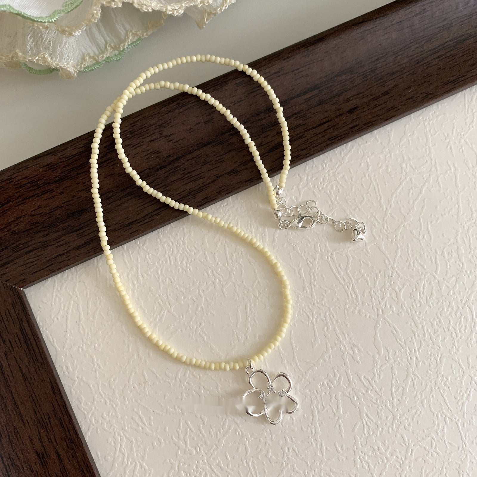 This women's necklace features a vibrant and delicate design, combining colorful yellow or blue beads with a hollow flower pendant.