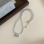 This women's necklace features a vibrant and delicate design, combining colorful yellow or blue beads with a hollow flower pendant.