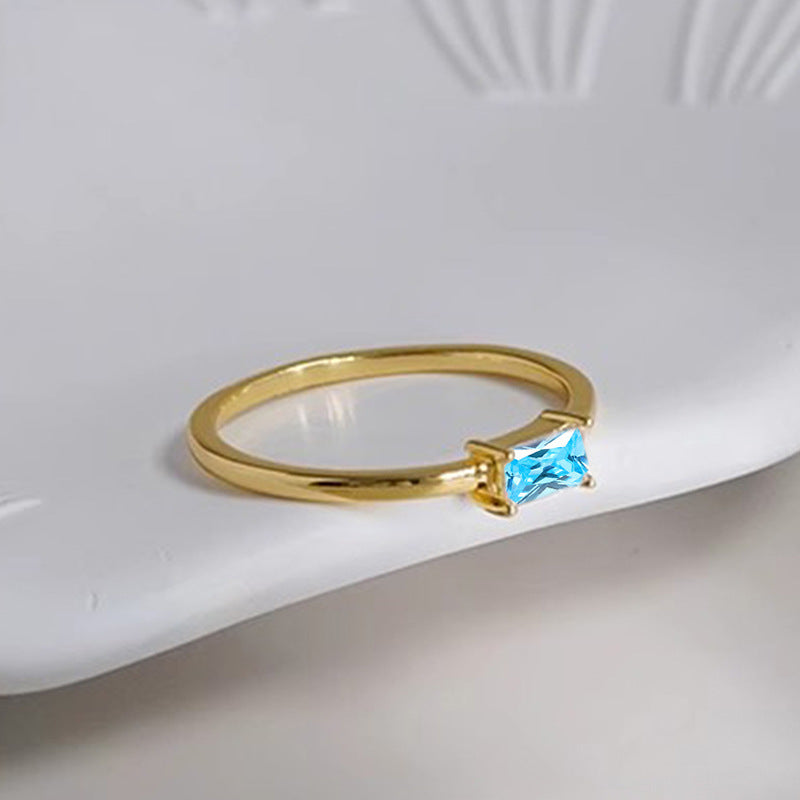 women's ring combines elegance and simplicity with its subtle geometric design highlighting an oval-shaped sapphire blue zircon