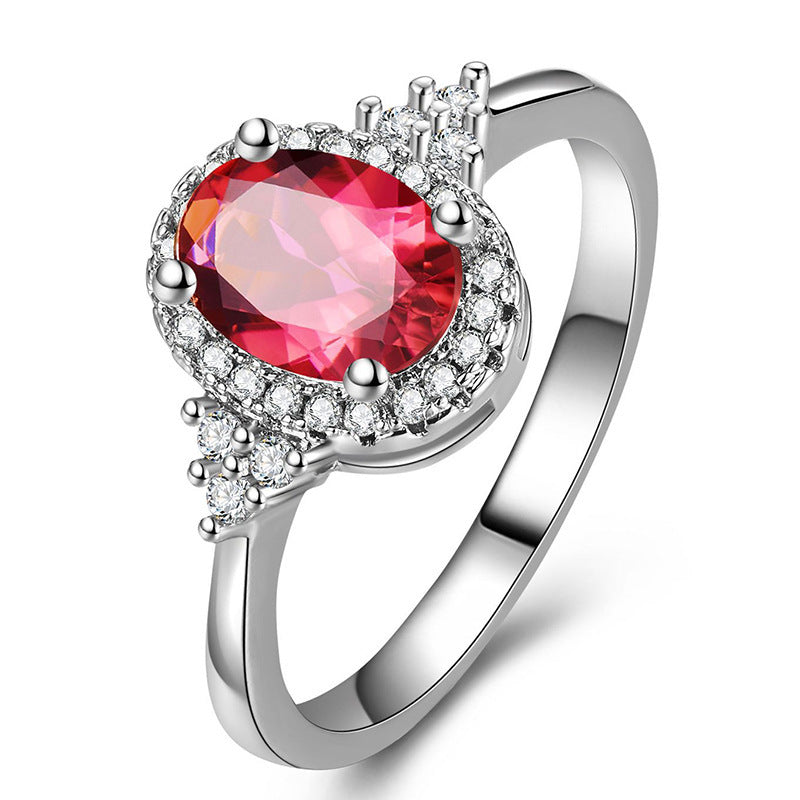 This women's ring is distinguished by its elegant oval shape, highlighting a sublime ruby ​​set in a white gold-plated copper metal.
