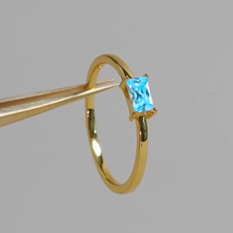 women's ring combines elegance and simplicity with its subtle geometric design highlighting an oval-shaped sapphire blue zircon
