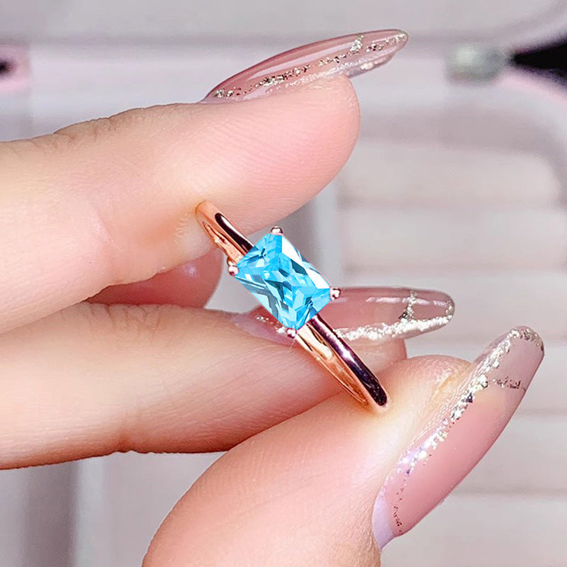 women's ring combines elegance and simplicity with its subtle geometric design highlighting an oval-shaped sapphire blue zircon
